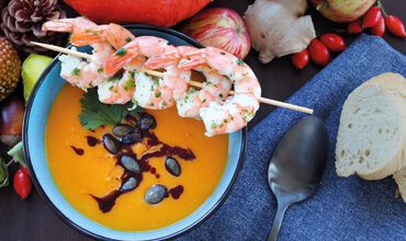 Pumpkin soup with prawn skewers